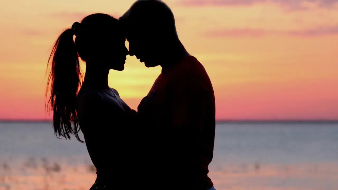 Casal em silhueta ao pôr do sol